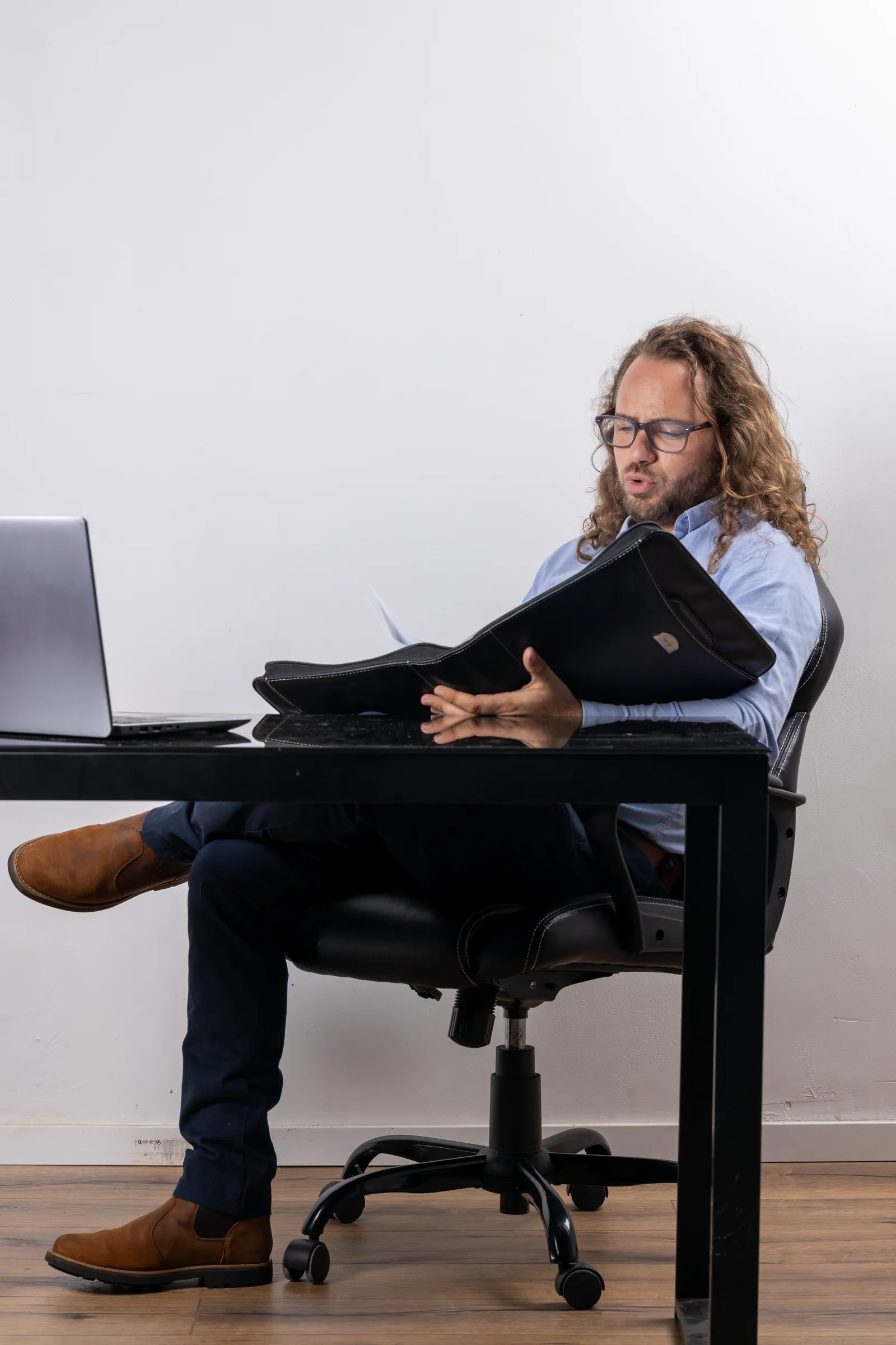 Sébastien Torre consultant un dossier client, dossier en main